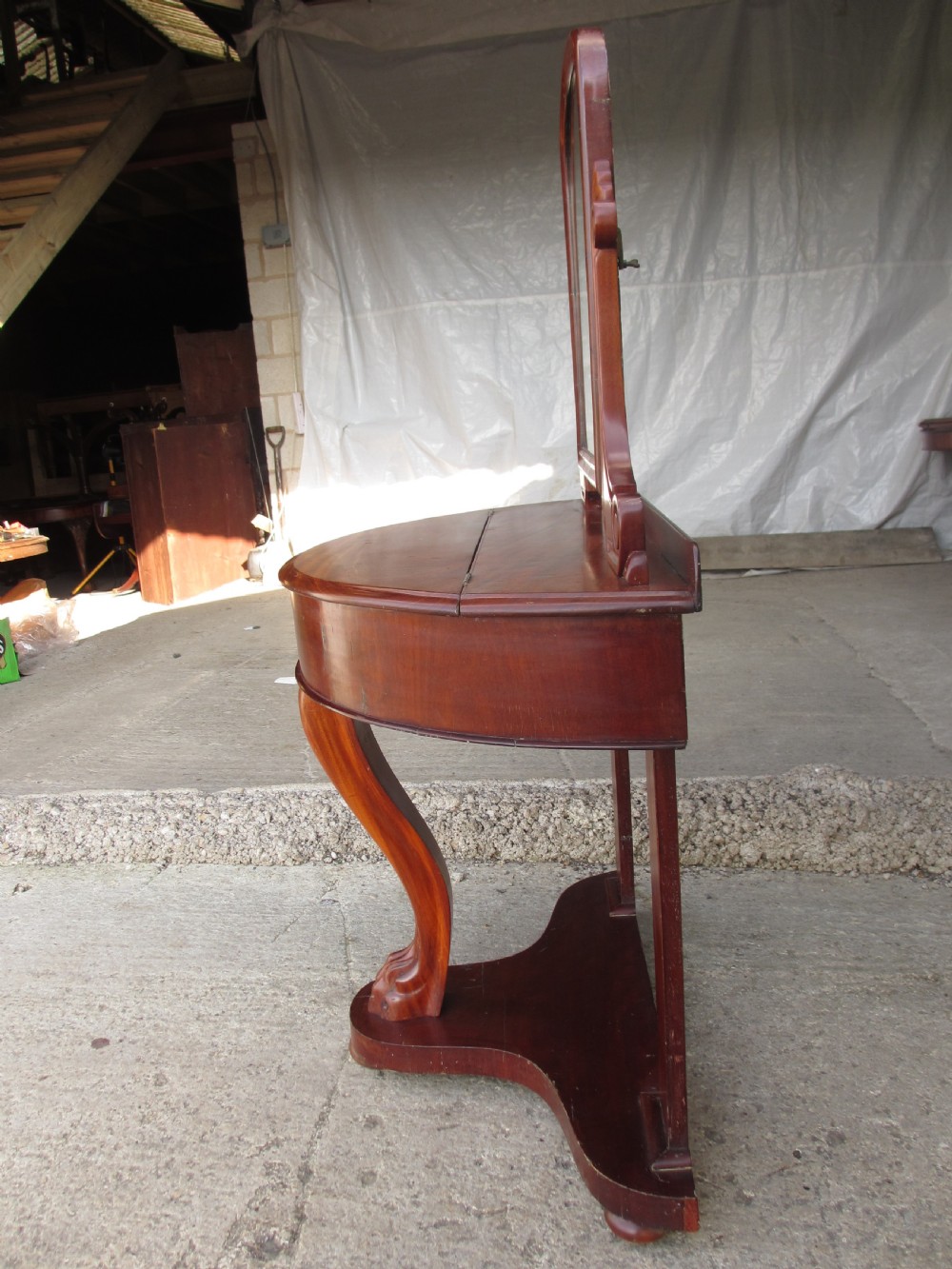 Victorian mahogany demi-lune dressing table featuring an arched swing mirror flanked by scrolled supports and a central carved cabriole front leg. View XIII