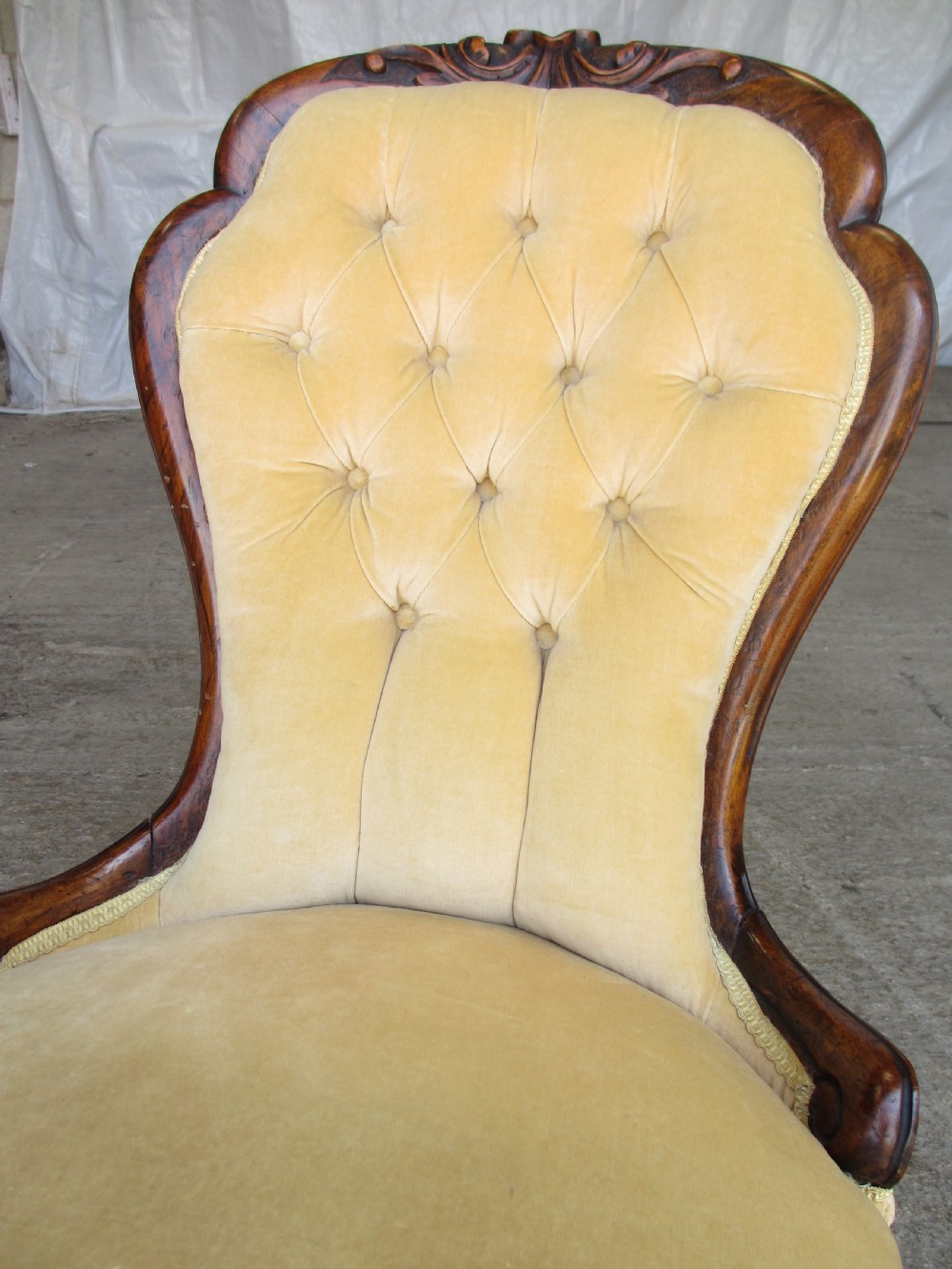 A Victorian spoon back nursing chair featuring yellow velvet button-tufted upholstery and a carved mahogany frame with cabriole legs. View IV