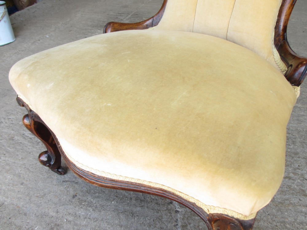 A Victorian spoon back nursing chair featuring yellow velvet button-tufted upholstery and a carved mahogany frame with cabriole legs. View VII