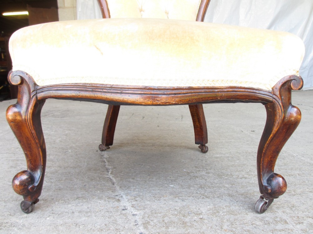 A Victorian spoon back nursing chair featuring yellow velvet button-tufted upholstery and a carved mahogany frame with cabriole legs. View VIII