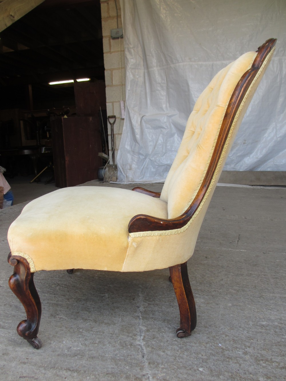 A Victorian spoon back nursing chair featuring yellow velvet button-tufted upholstery and a carved mahogany frame with cabriole legs. View IX