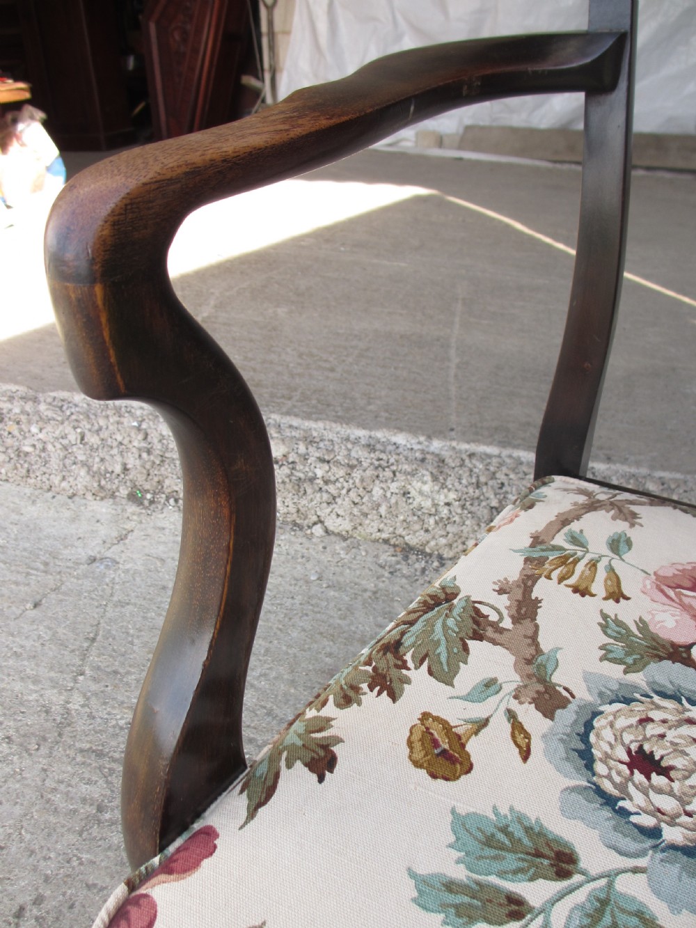 A 19th-century dark mahogany carver armchair featuring a shaped vase back splat, cabriole front legs with pad feet, and a drop-in floral tapestry seat pad. View IV