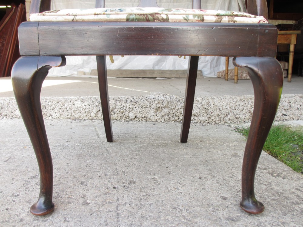 A 19th-century dark mahogany carver armchair featuring a shaped vase back splat, cabriole front legs with pad feet, and a drop-in floral tapestry seat pad. View V