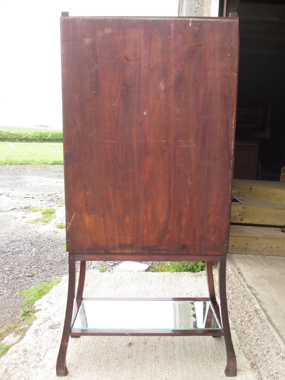 A late 19th-century mahogany Art Nouveau display cabinet featuring leaded glass doors with green accents, stylized glazing bars, interior glass shelving, and a lower open undertier. View XI