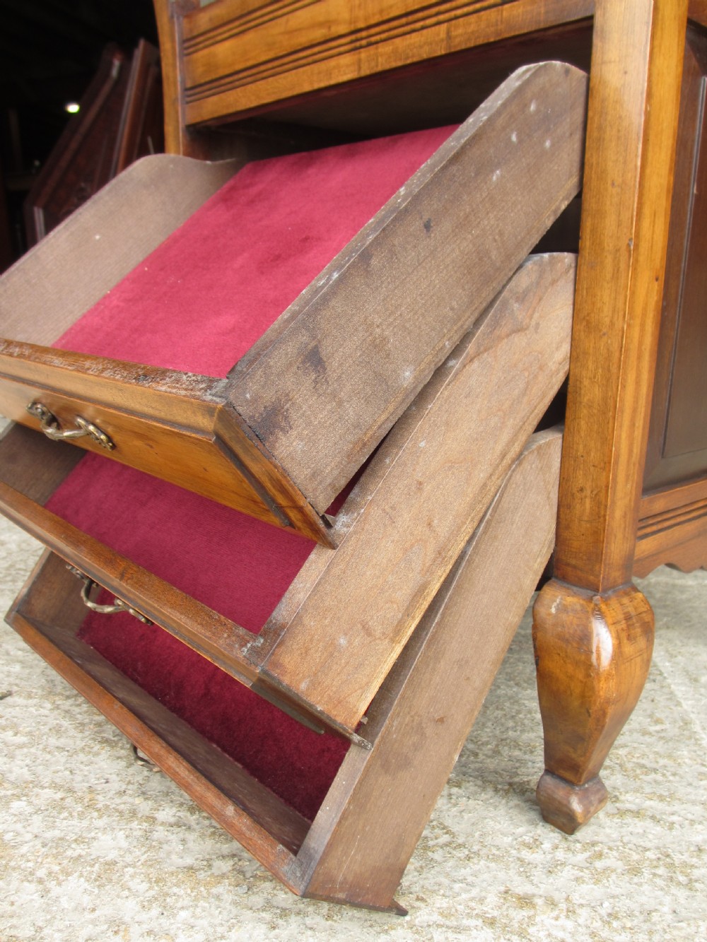 An Edwardian mahogany music stool featuring a red velvet upholstered seat, side turned handles, brass drawer pulls, and cabriole legs. View VI