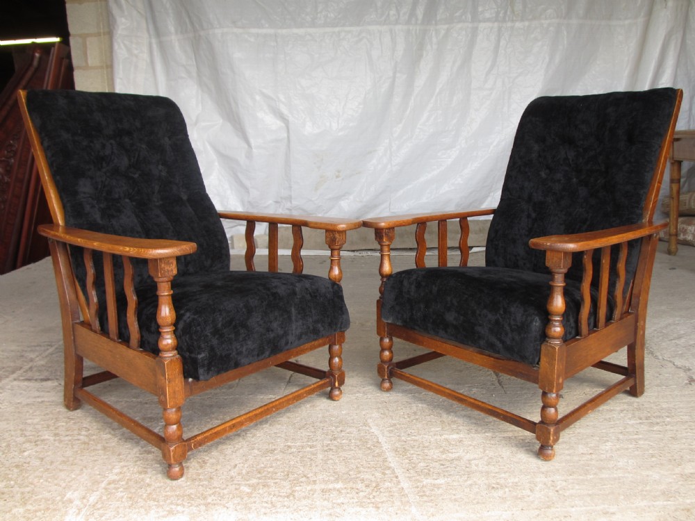 A pair of Edwardian oak plantation style Art Deco adjustable lean back armchairs