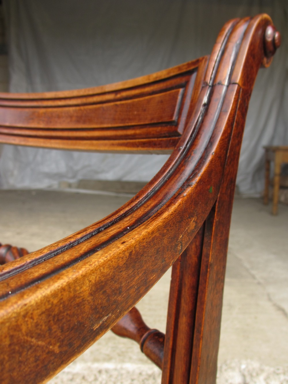 A Georgian mahogany armchair featuring curved reeded arms, a carved rope-twist horizontal back bar, turned front supports, and a tan drop-in upholstered seat. View II