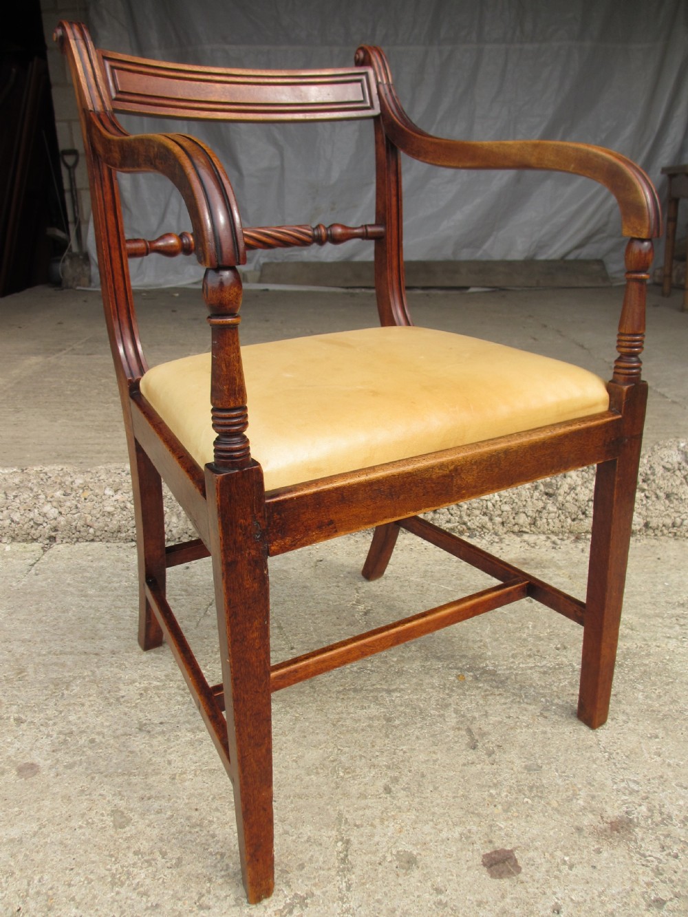 A Georgian mahogany armchair featuring curved reeded arms, a carved rope-twist horizontal back bar, turned front supports, and a tan drop-in upholstered seat. View IV
