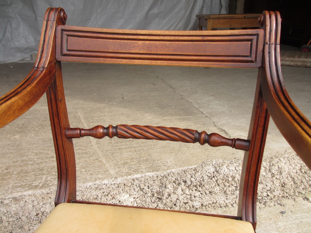 A Georgian mahogany armchair featuring curved reeded arms, a carved rope-twist horizontal back bar, turned front supports, and a tan drop-in upholstered seat. View VII