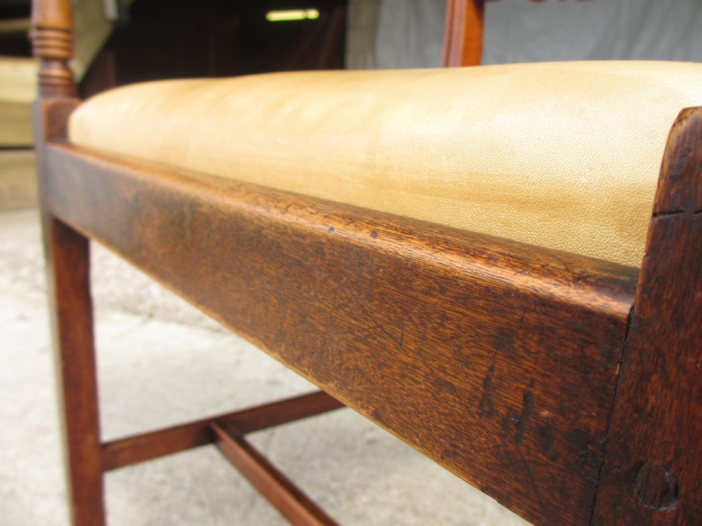 A Georgian mahogany armchair featuring curved reeded arms, a carved rope-twist horizontal back bar, turned front supports, and a tan drop-in upholstered seat. View X