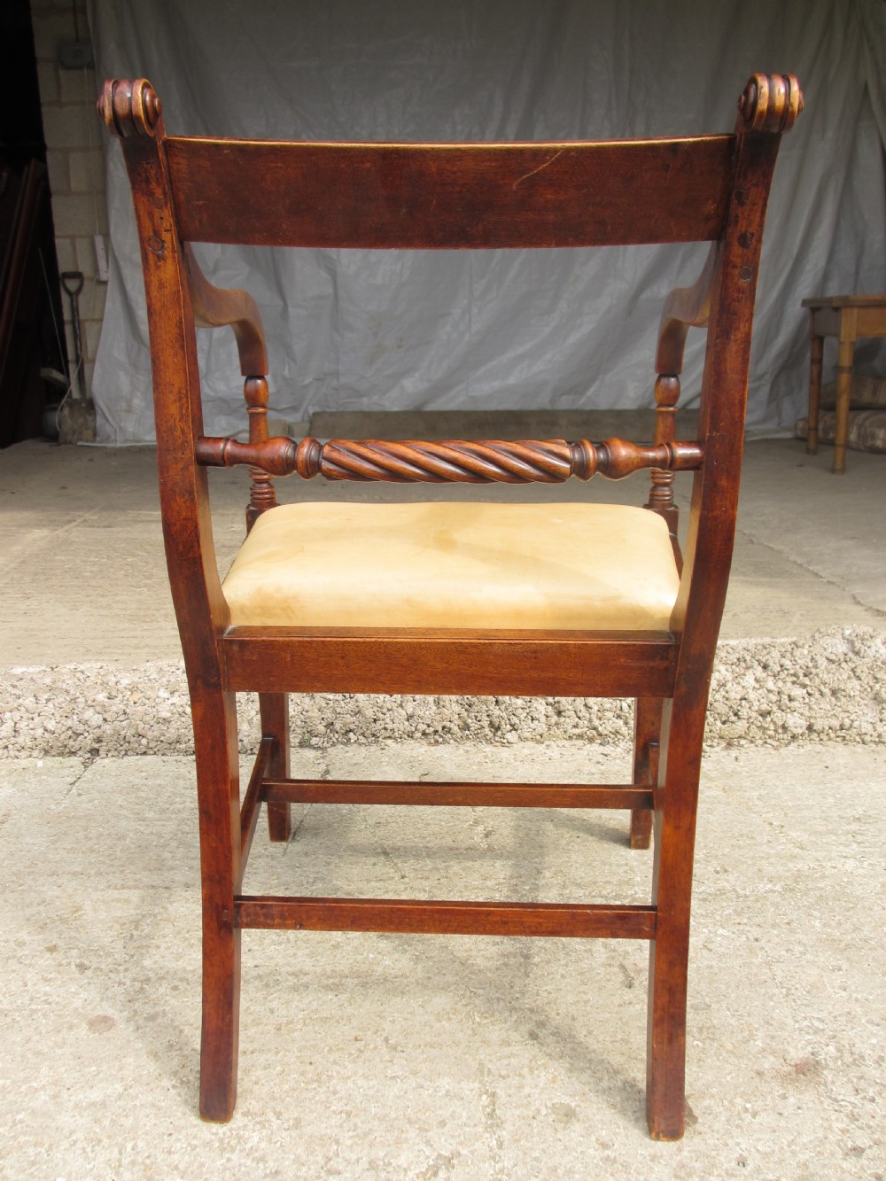 A Georgian mahogany armchair featuring curved reeded arms, a carved rope-twist horizontal back bar, turned front supports, and a tan drop-in upholstered seat. View XII