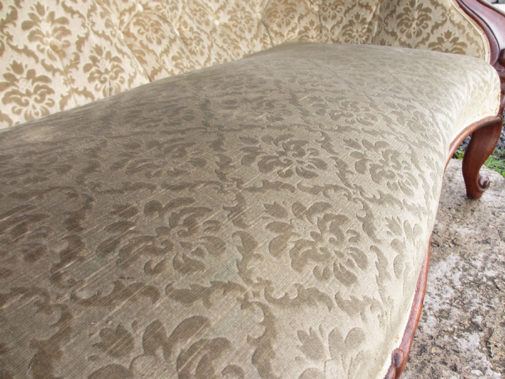 An early Victorian mahogany showood sofa with button-tufted gold damask upholstery and carved cabriole legs. View V