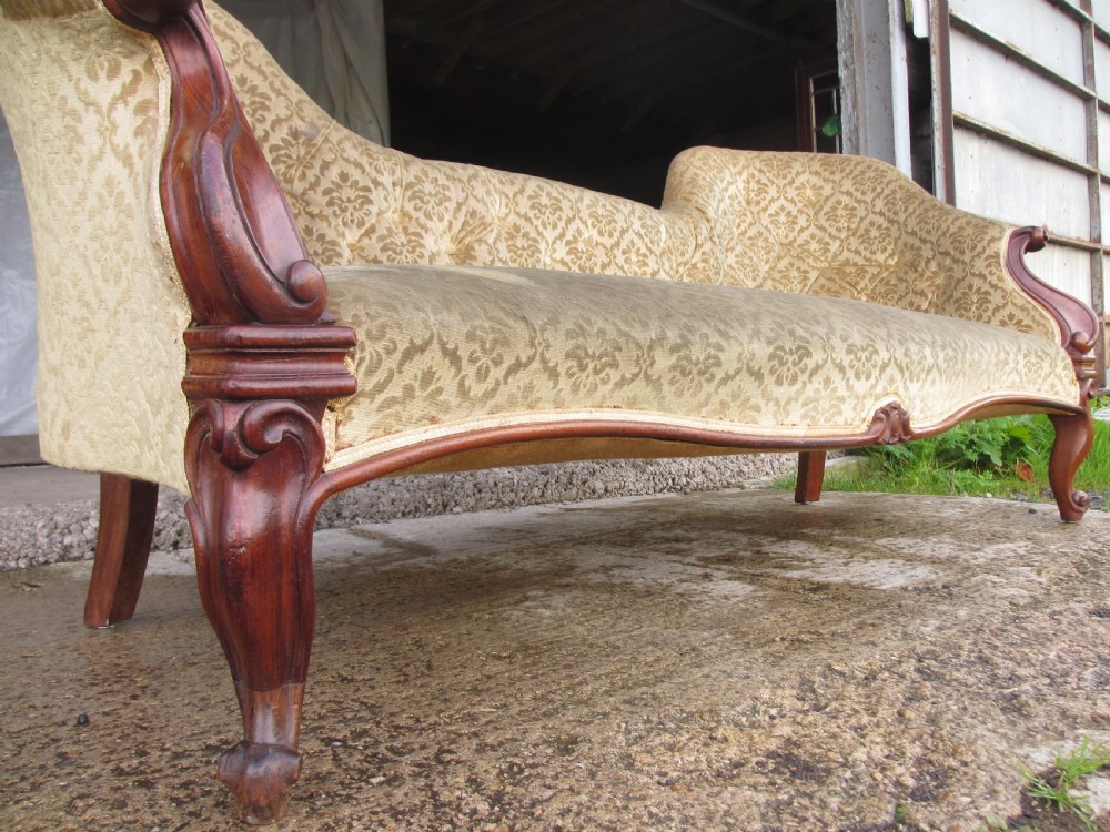 An early Victorian mahogany showood sofa with button-tufted gold damask upholstery and carved cabriole legs. View VI