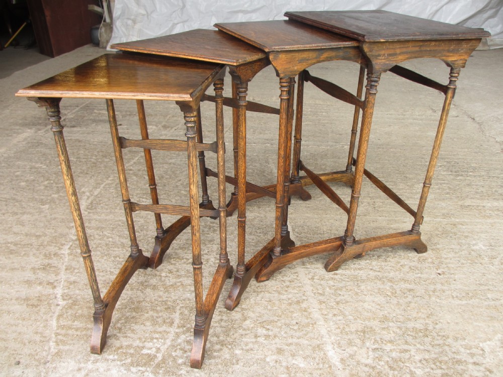 A set of four graduating nineteenth-century oak nesting tables with slender turned legs and rectangular tops.