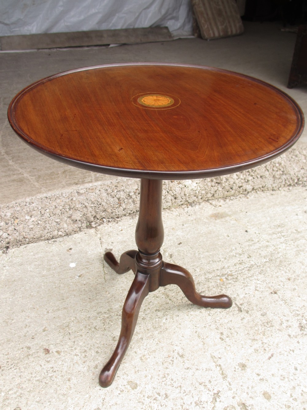 A circular Georgian mahogany tripod table featuring a central inlaid satinwood rosette, turned pedestal stem, and three curved legs. View II