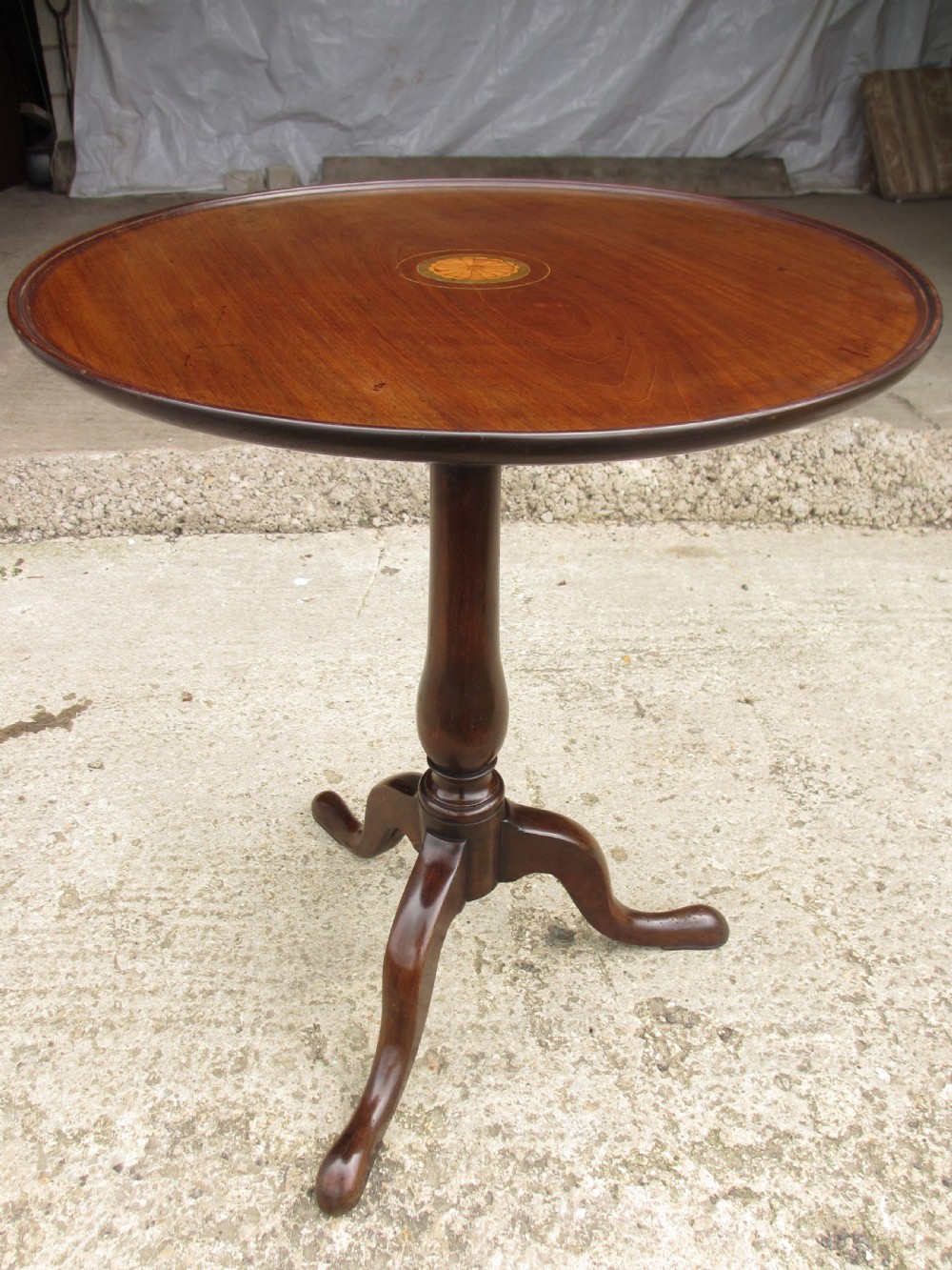 A circular Georgian mahogany tripod table featuring a central inlaid satinwood rosette, turned pedestal stem, and three curved legs. View IV