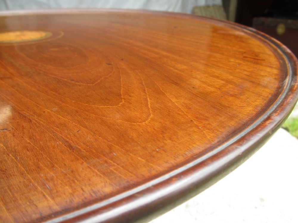 A circular Georgian mahogany tripod table featuring a central inlaid satinwood rosette, turned pedestal stem, and three curved legs. View VI