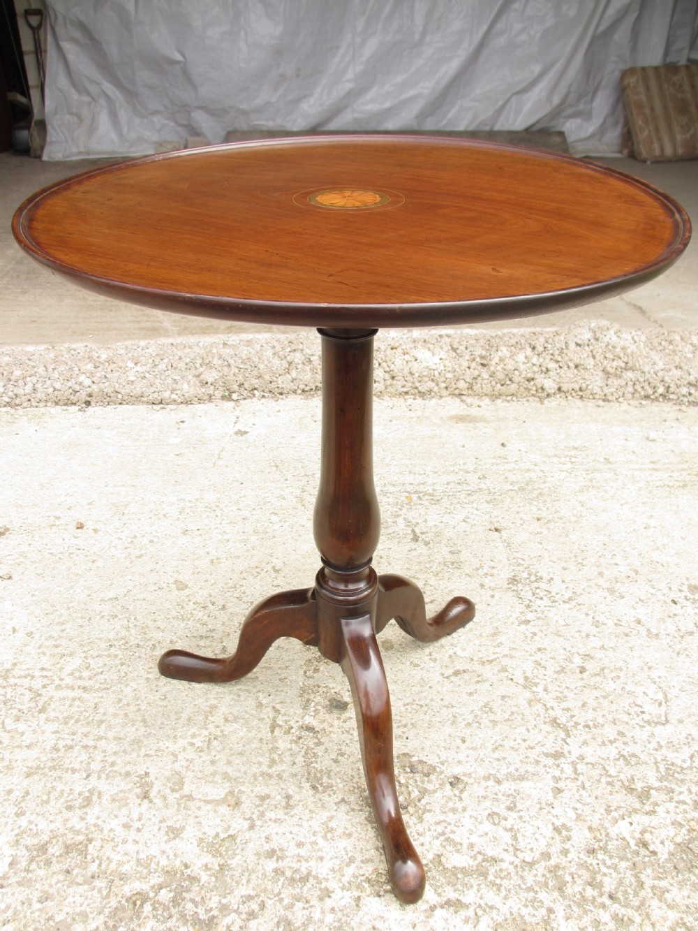 A circular Georgian mahogany tripod table featuring a central inlaid satinwood rosette, turned pedestal stem, and three curved legs. View XI