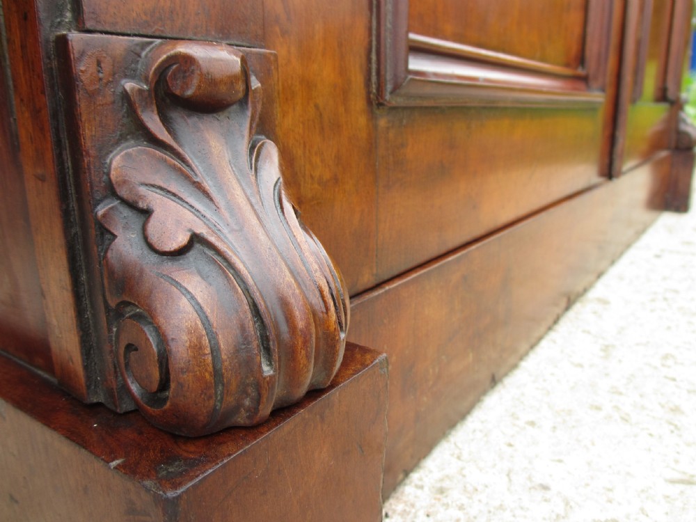 A Victorian mahogany chiffonier featuring two lower cupboard doors with figured plum pudding veneer panels, topped with two open display shelves supported by carved scroll brackets and a fretwork cresting. View VII