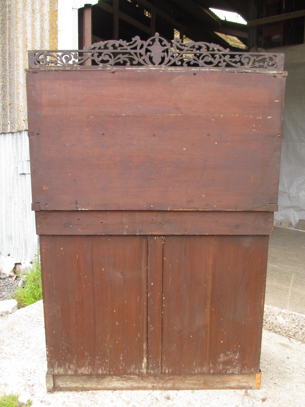 A Victorian mahogany chiffonier featuring two lower cupboard doors with figured plum pudding veneer panels, topped with two open display shelves supported by carved scroll brackets and a fretwork cresting. View XIII