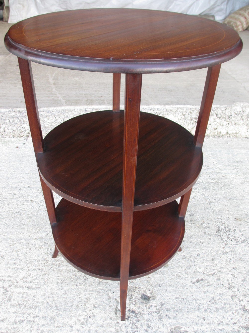 An Edwardian circular dark mahogany etagere featuring three tiers supported by four slender legs with inlaid edge detailing. View III