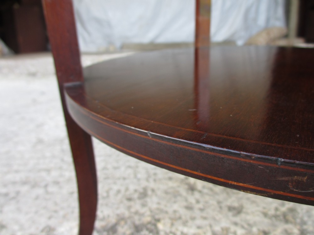An Edwardian circular dark mahogany etagere featuring three tiers supported by four slender legs with inlaid edge detailing. View XI