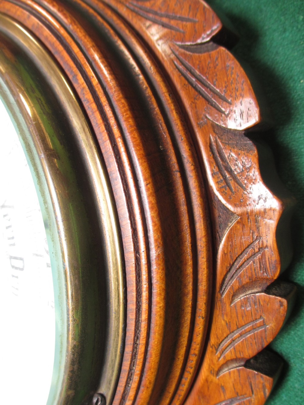 A Victorian carved oak wall barometer featuring an upper thermometer, intricate leaf scrollwork motifs, and a circular white dial with a brass bezel. View VIII