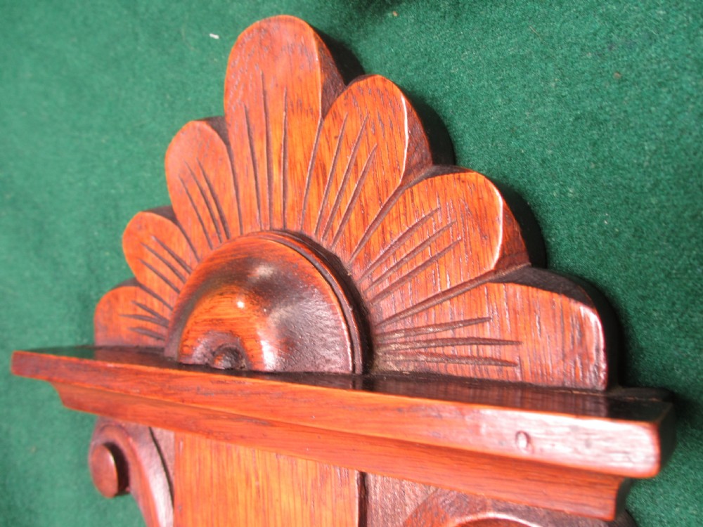 A Victorian carved oak wall barometer featuring an upper thermometer, intricate leaf scrollwork motifs, and a circular white dial with a brass bezel. View X
