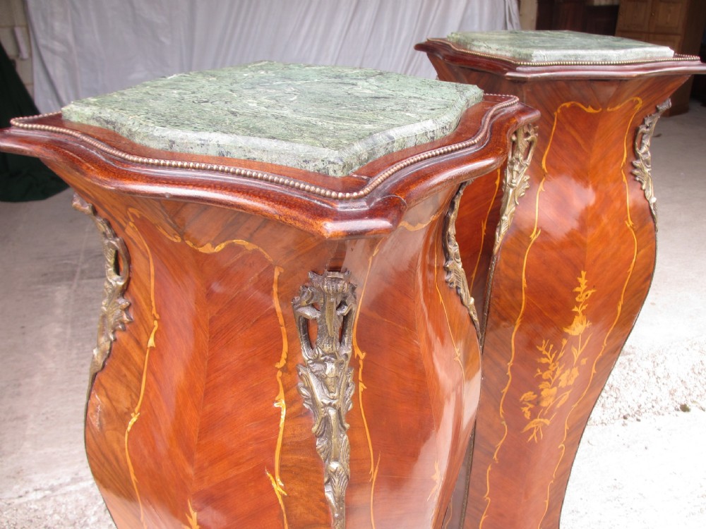 A pair of tall French Louis XV style wooden pedestals featuring floral marquetry inlays, curved silhouettes, and decorative gilt-bronze mounts. View VI