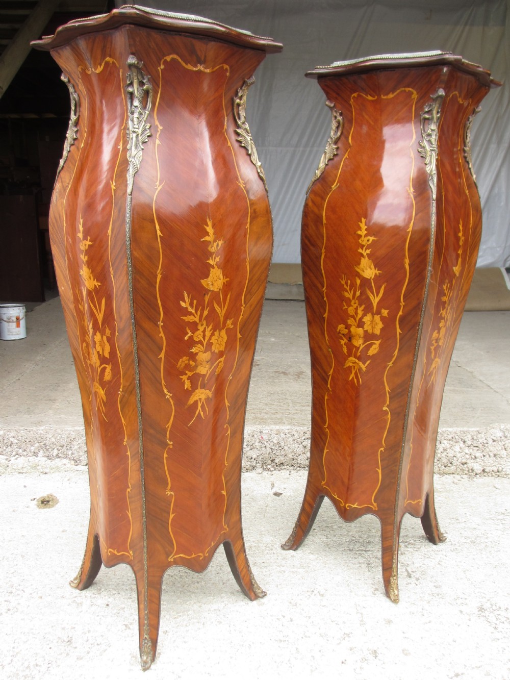 A pair of tall French Louis XV style wooden pedestals featuring floral marquetry inlays, curved silhouettes, and decorative gilt-bronze mounts. View VII