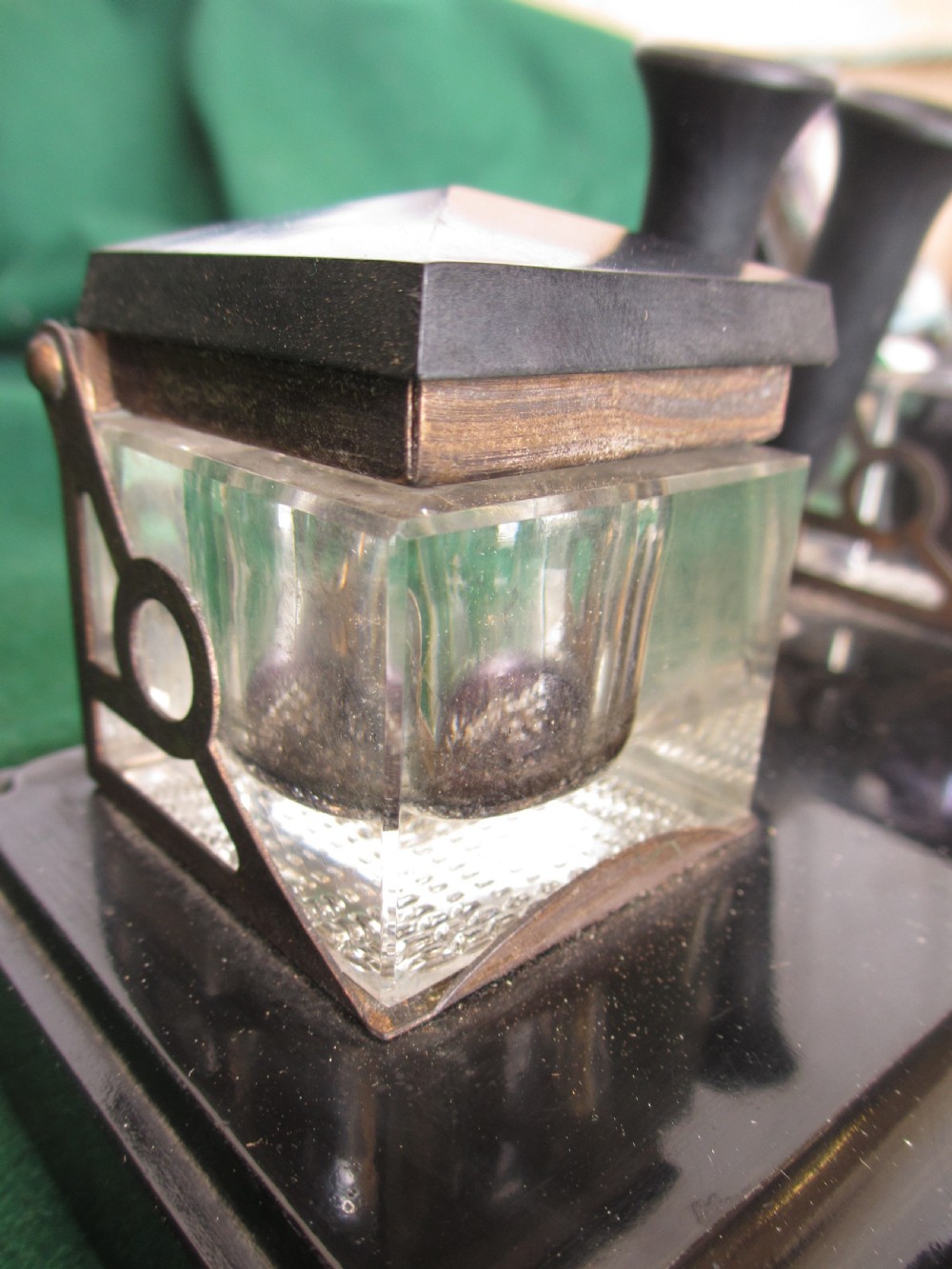 A Victorian inkstand featuring a black base with a front pen groove, two upright trumpet pen rests, and two square glass inkwells with dark lids. View VIII