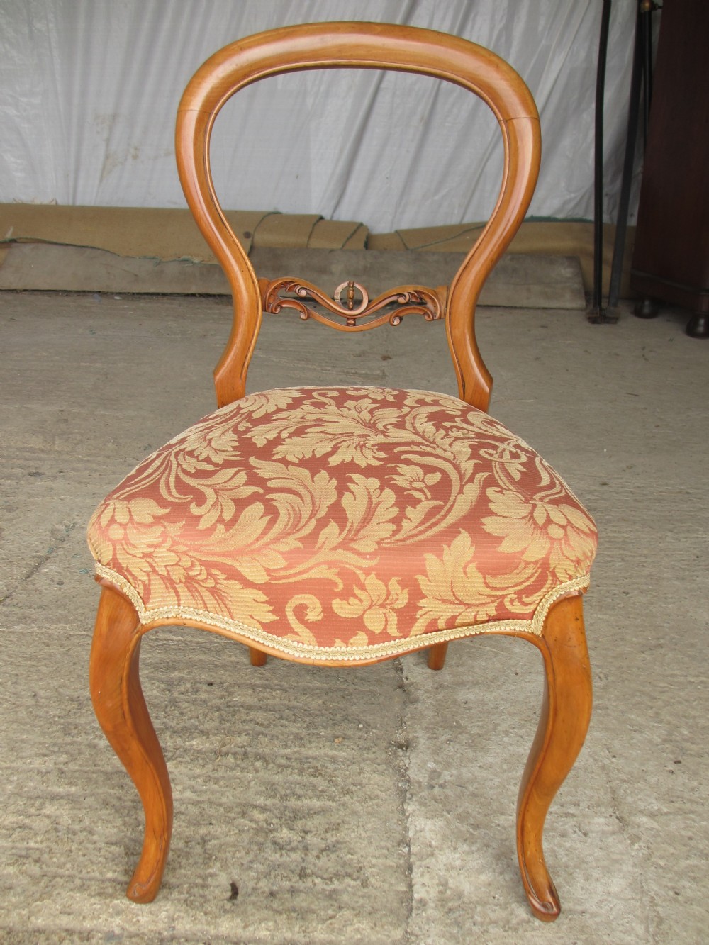 A set of three Victorian mahogany dining chairs featuring rounded balloon backs, carved central splats, cabriole front legs, and terracotta floral upholstery. View II