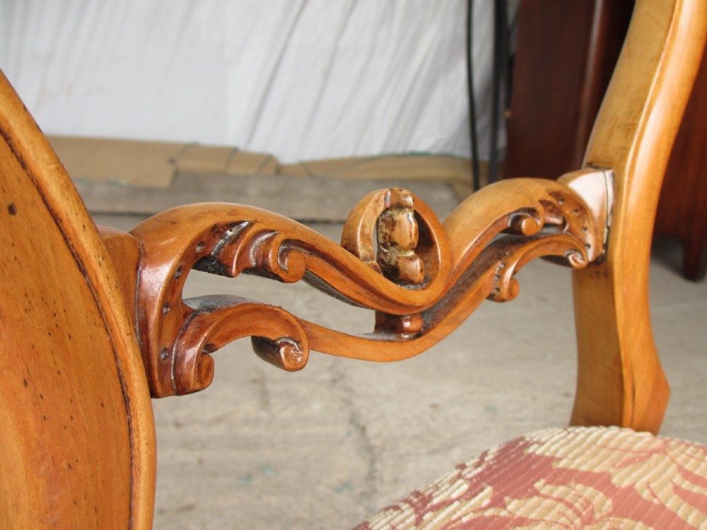 A set of three Victorian mahogany dining chairs featuring rounded balloon backs, carved central splats, cabriole front legs, and terracotta floral upholstery. View V