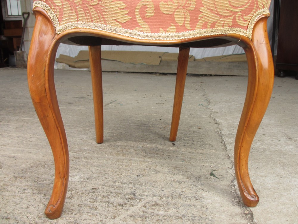 A set of three Victorian mahogany dining chairs featuring rounded balloon backs, carved central splats, cabriole front legs, and terracotta floral upholstery. View VII