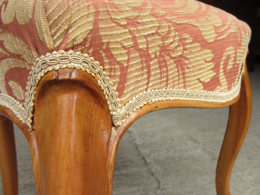 A set of three Victorian mahogany dining chairs featuring rounded balloon backs, carved central splats, cabriole front legs, and terracotta floral upholstery. View VIII