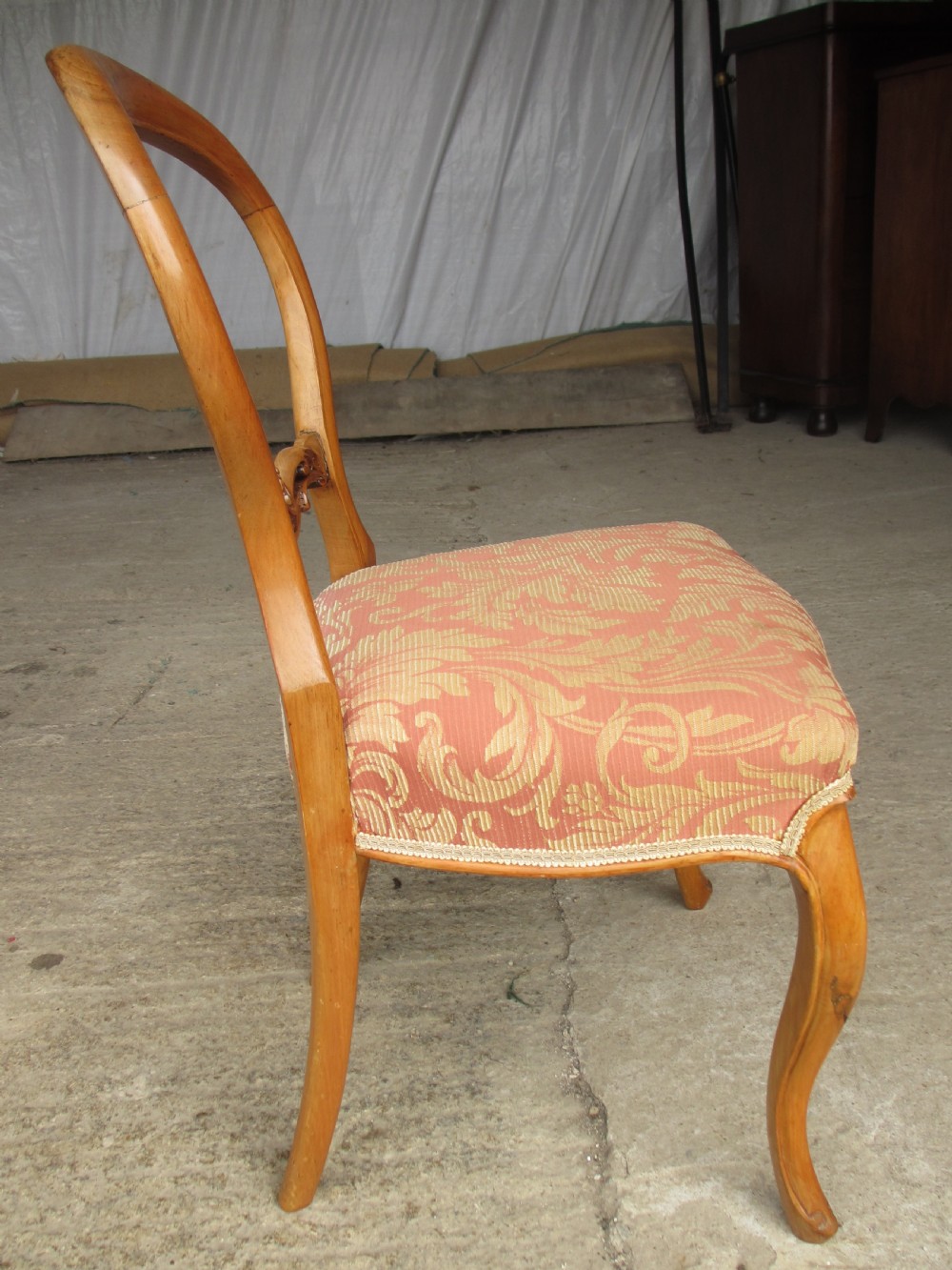 A set of three Victorian mahogany dining chairs featuring rounded balloon backs, carved central splats, cabriole front legs, and terracotta floral upholstery. View IX