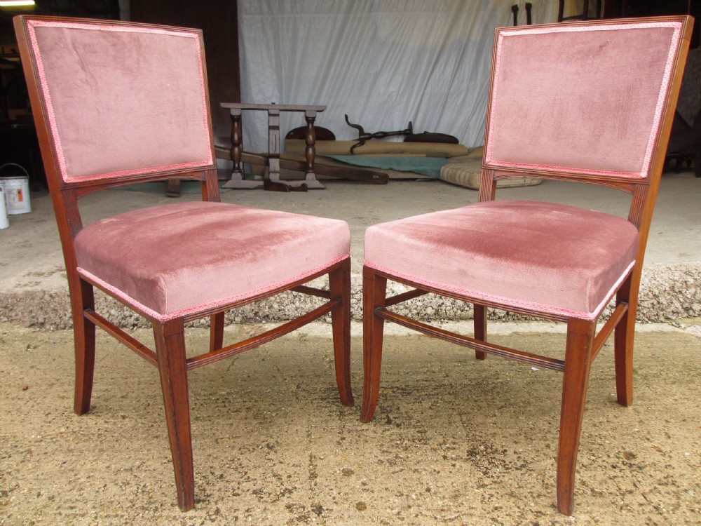 A pair of 19th-century mahogany dining chairs featuring upholstered dusty pink velvet rectangular backs and seats with reeded wooden legs. View II