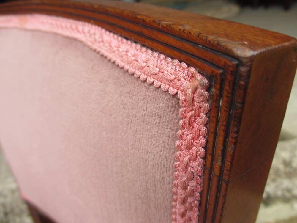 A pair of 19th-century mahogany dining chairs featuring upholstered dusty pink velvet rectangular backs and seats with reeded wooden legs. View VI