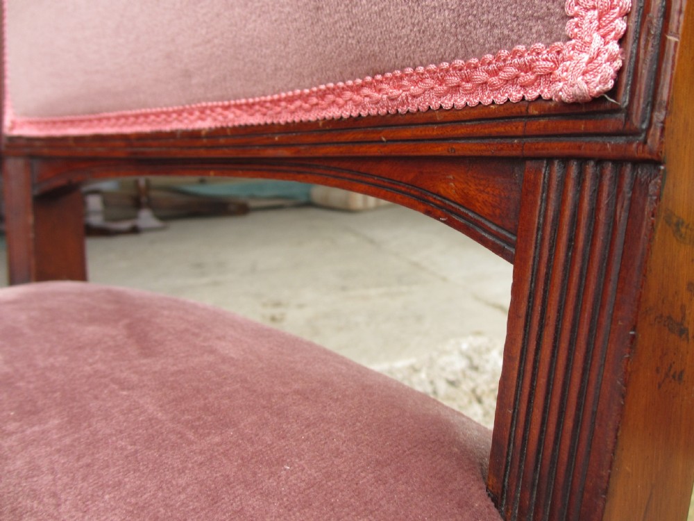 A pair of 19th-century mahogany dining chairs featuring upholstered dusty pink velvet rectangular backs and seats with reeded wooden legs. View VII