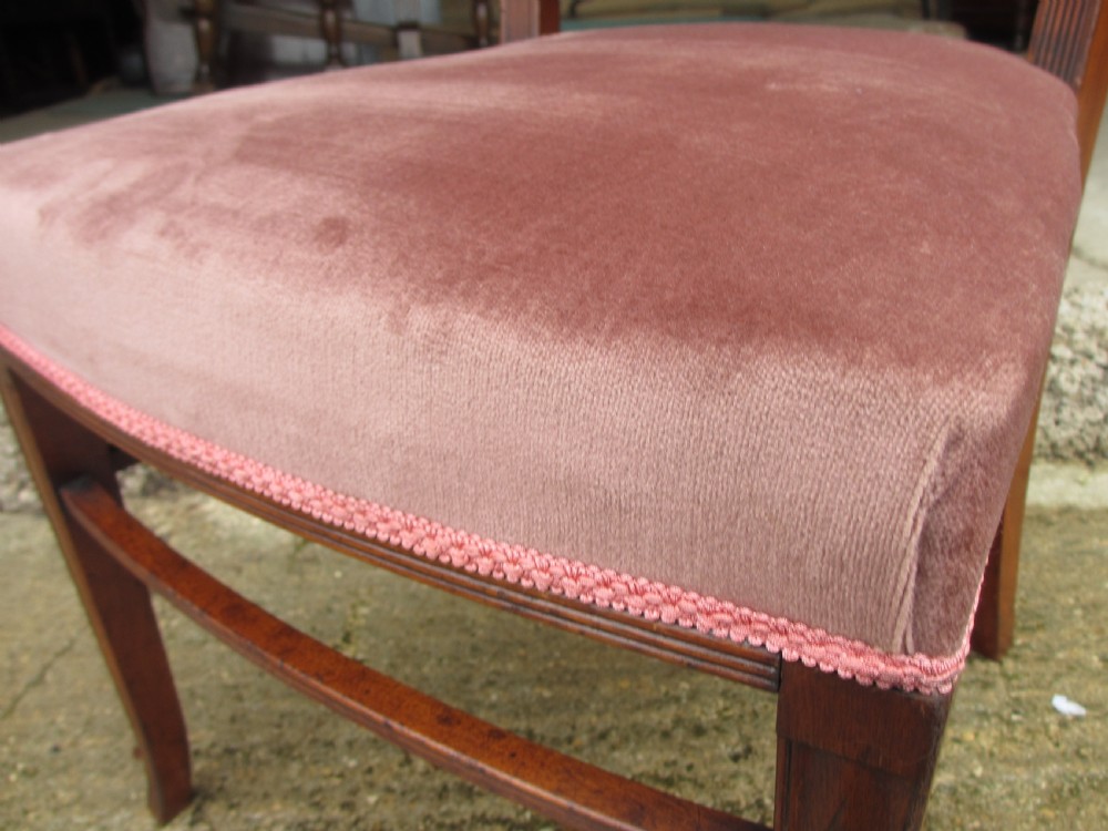 A pair of 19th-century mahogany dining chairs featuring upholstered dusty pink velvet rectangular backs and seats with reeded wooden legs. View VIII