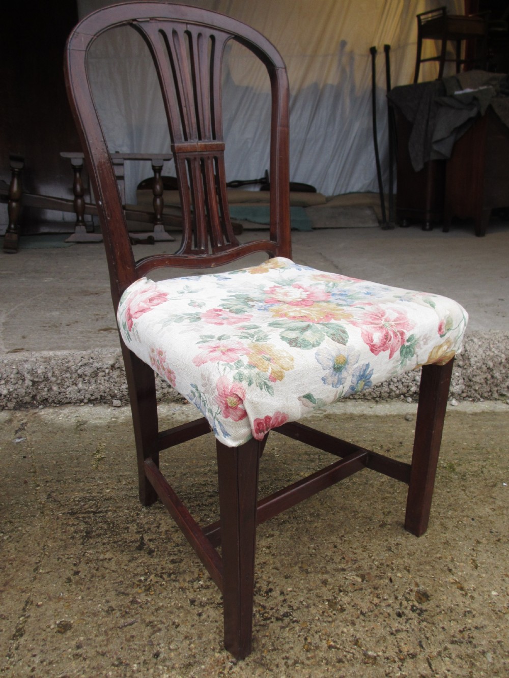 A pair of 19th-century mahogany dining chairs featuring openwork pierced vase splats, square legs with stretchers, and floral drop-in fabric seats. View III