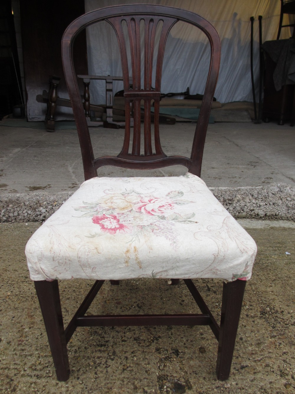 A pair of 19th-century mahogany dining chairs featuring openwork pierced vase splats, square legs with stretchers, and floral drop-in fabric seats. View IV