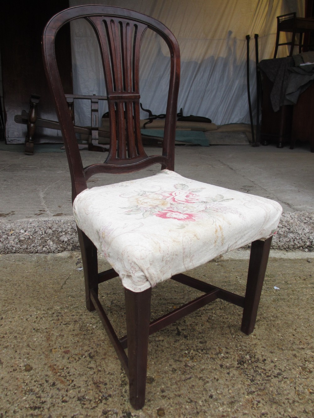 A pair of 19th-century mahogany dining chairs featuring openwork pierced vase splats, square legs with stretchers, and floral drop-in fabric seats. View V