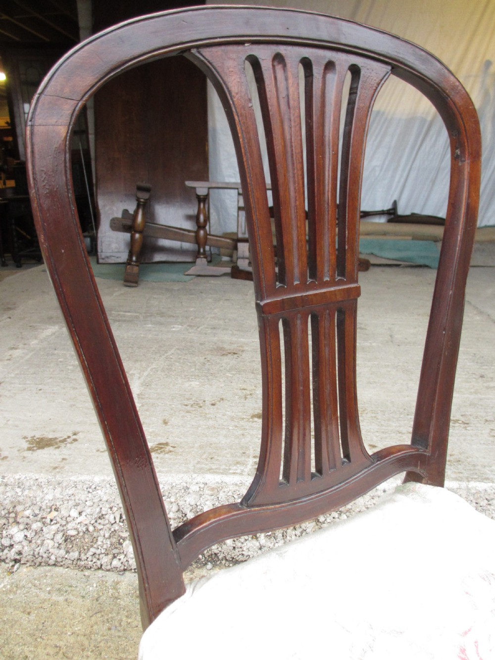 A pair of 19th-century mahogany dining chairs featuring openwork pierced vase splats, square legs with stretchers, and floral drop-in fabric seats. View VI