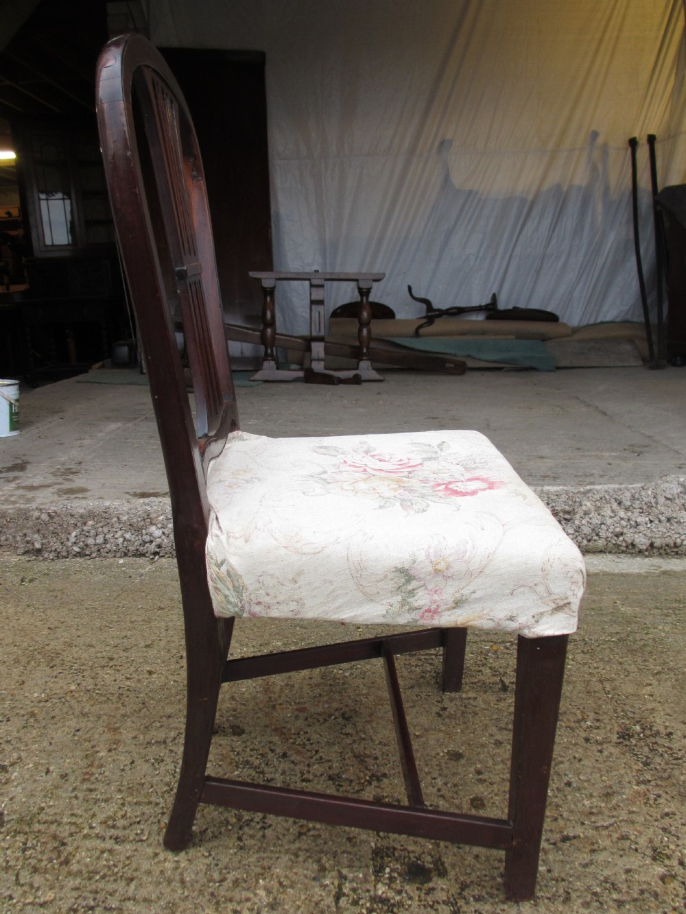 A pair of 19th-century mahogany dining chairs featuring openwork pierced vase splats, square legs with stretchers, and floral drop-in fabric seats. View X