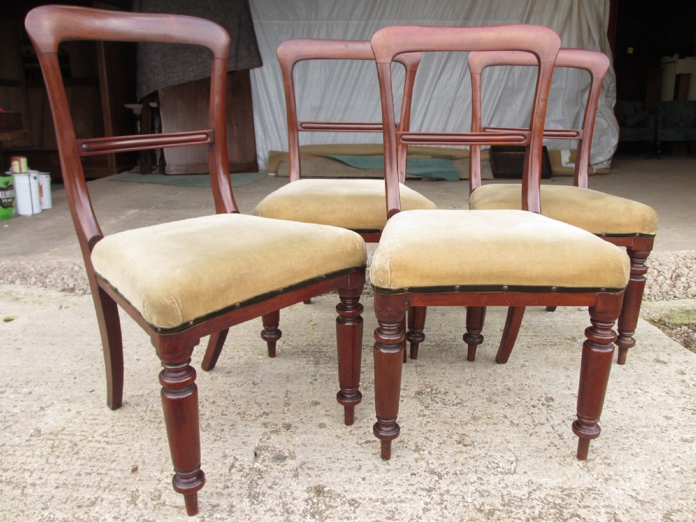 A set of four 19th-century mahogany dining chairs with curved bar backs, turned front legs, and cushioned tan velvet seats. View V