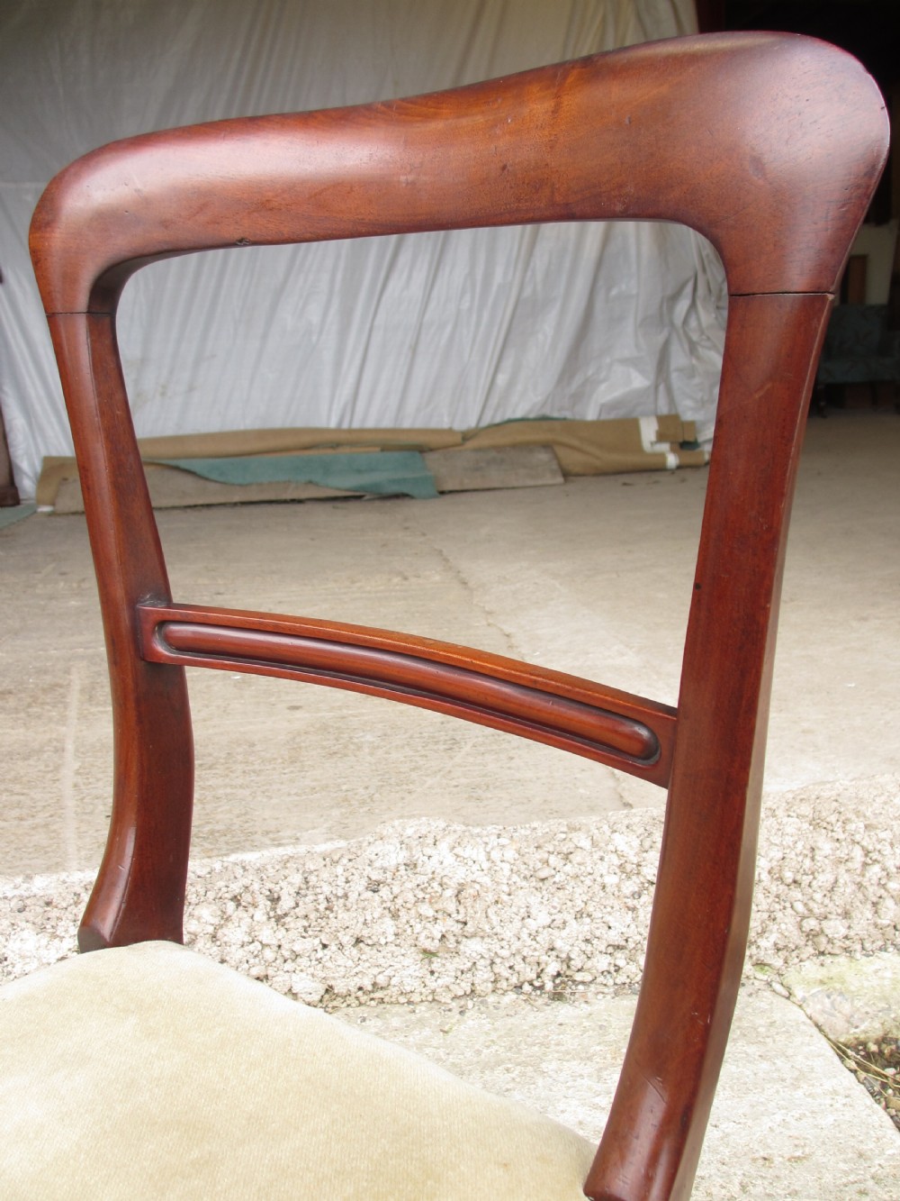 A set of four 19th-century mahogany dining chairs with curved bar backs, turned front legs, and cushioned tan velvet seats. View VII