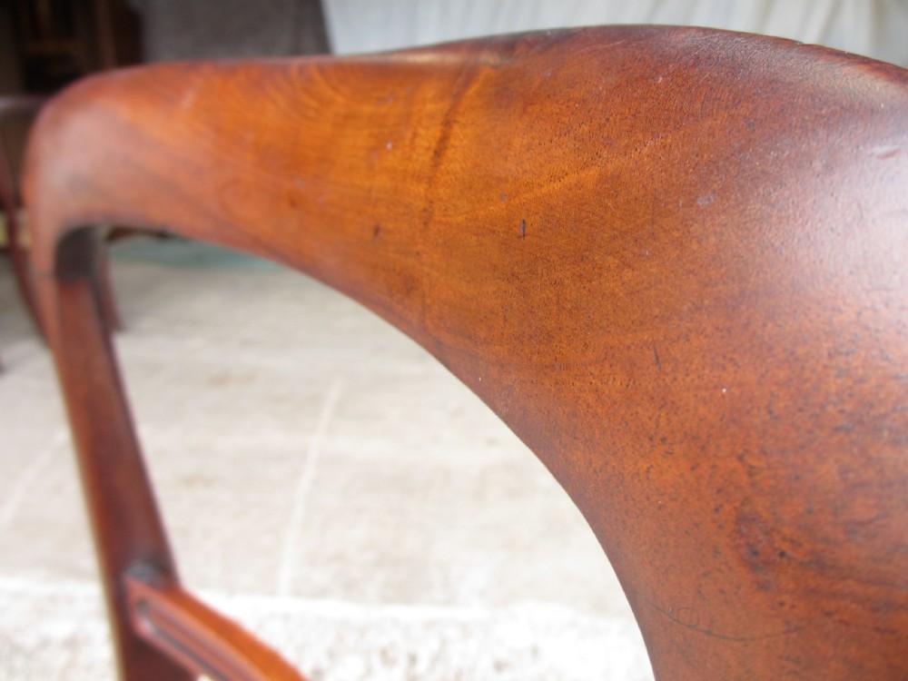 A set of four 19th-century mahogany dining chairs with curved bar backs, turned front legs, and cushioned tan velvet seats. View VIII