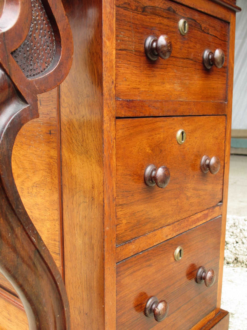 A Victorian rosewood davenport secretaire desk featuring an open black leather-lined writing slope, an upper gallery with drawers and pigeonholes, side drawers, and carved cabriole supports. View VII