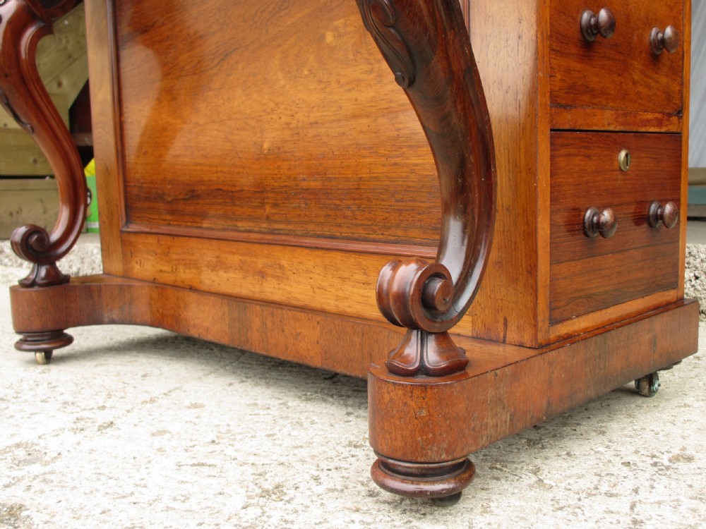 A Victorian rosewood davenport secretaire desk featuring an open black leather-lined writing slope, an upper gallery with drawers and pigeonholes, side drawers, and carved cabriole supports. View IX